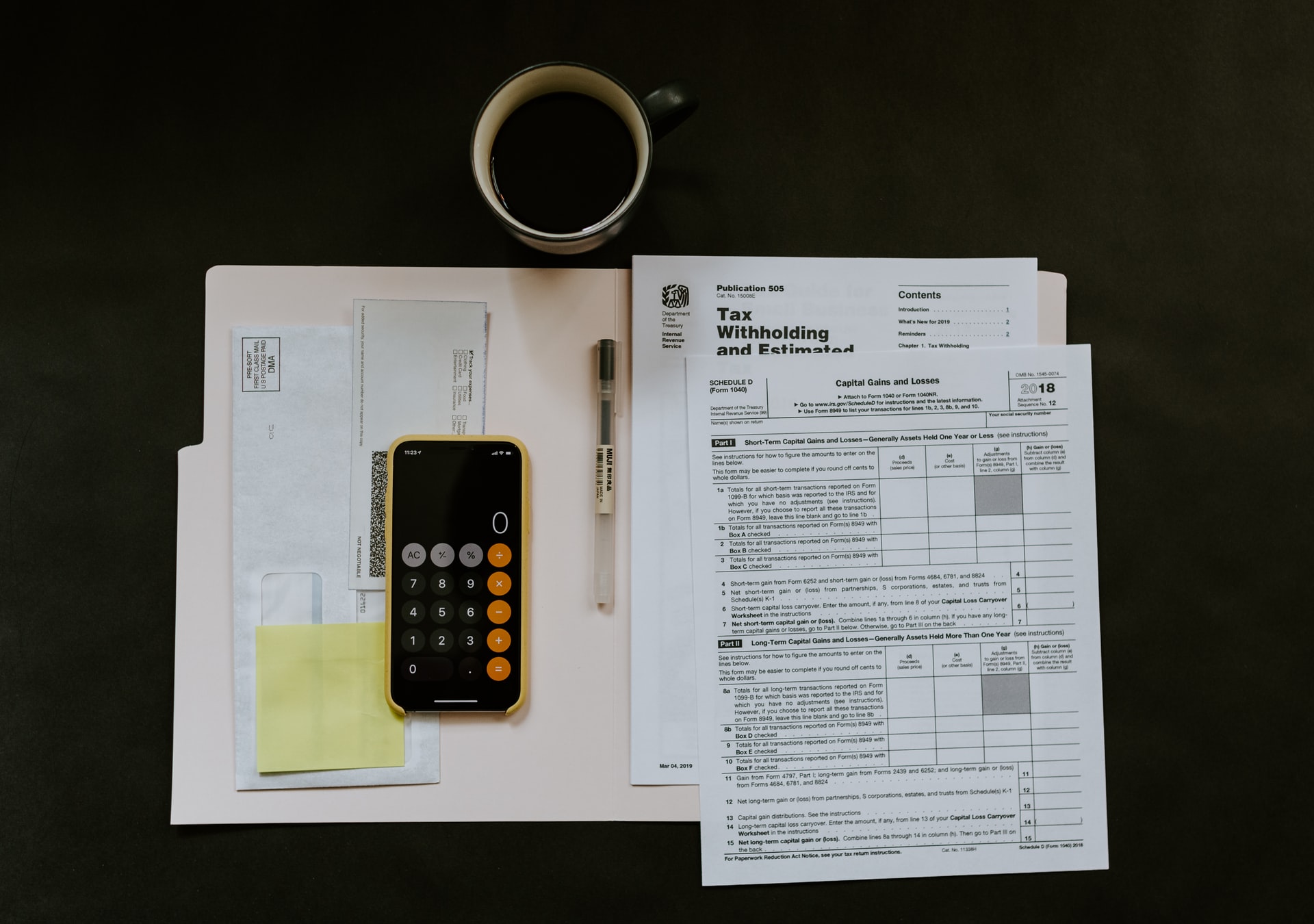 Open file with tax forms a pen and a coffee on a table