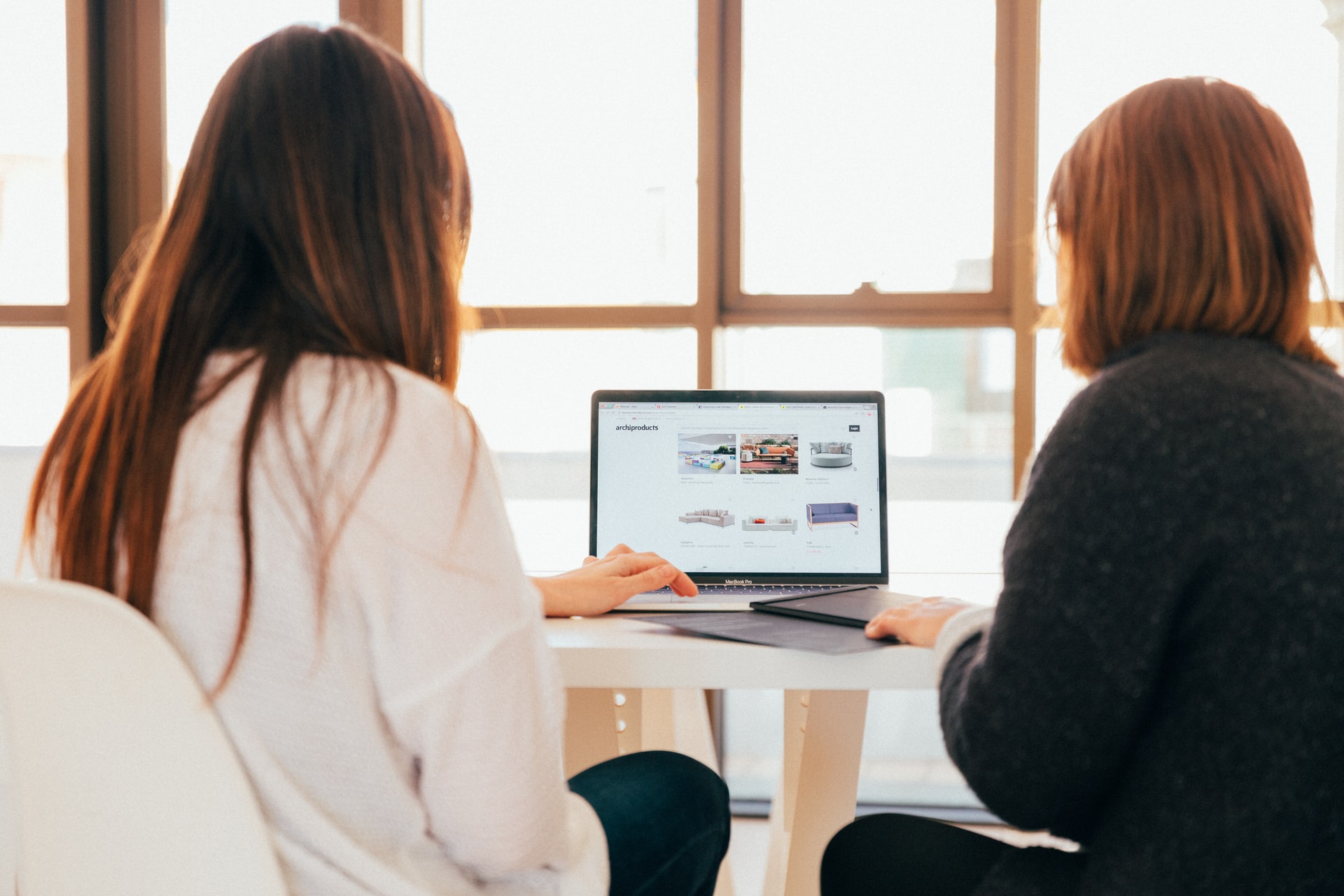 Two women looking at their website on a laptop computer